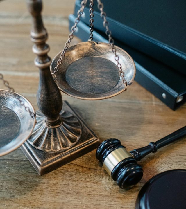 From above of judicial symbols consisting of Scales of Justice and small judge hammer with curly handle